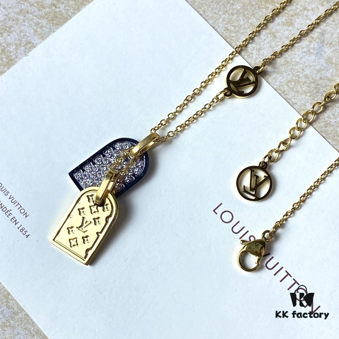A pair of name tags engraved with the classic LV Initials signature, featuring contrasting gold and silver finishes, a soft pearl chain, and a buckle adorned with the LV Circle logo.