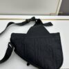 This boxed saddle bag is a new piece from the classic collection, meticulously crafted from black grained leather. A magnetic flap conceals a zip pocket for daily essentials, and it features an adjustable Christian Dior jacquard webbing strap for shoulder or crossbody wear.