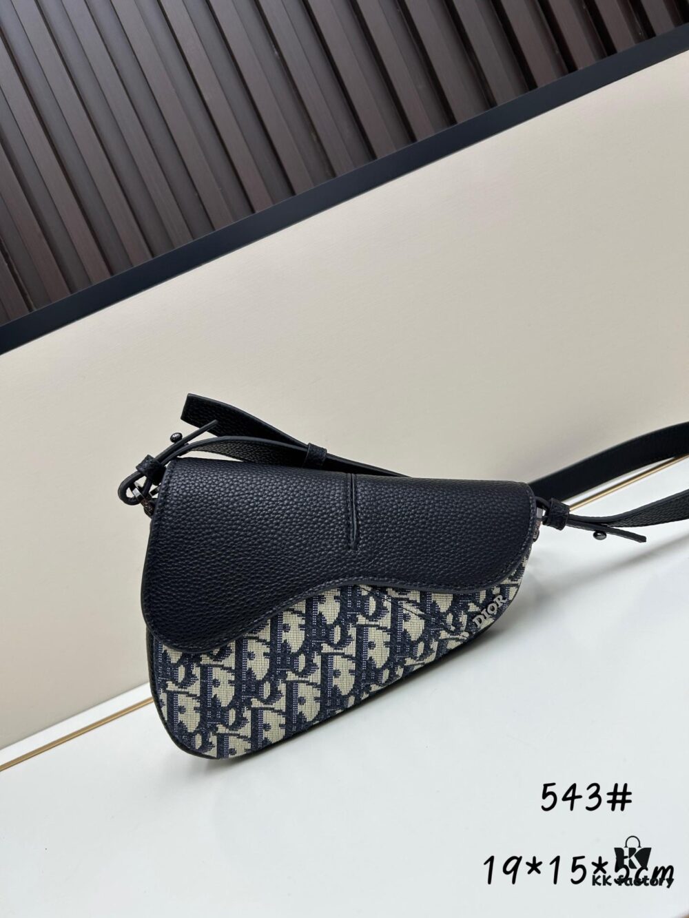 This saddle bag reinterprets the classic design with a modern structure. Crafted from beige and black Oblique printed fabric, it features a signature black grained cowhide leather magnetic flap and a concealed zip closure. The interior includes a large compartment and slip pockets for daily essentials. The mini style comes with an adjustable, detachable leather shoulder strap, allowing versatile wear as a top handle, shoulder bag, or crossbody.