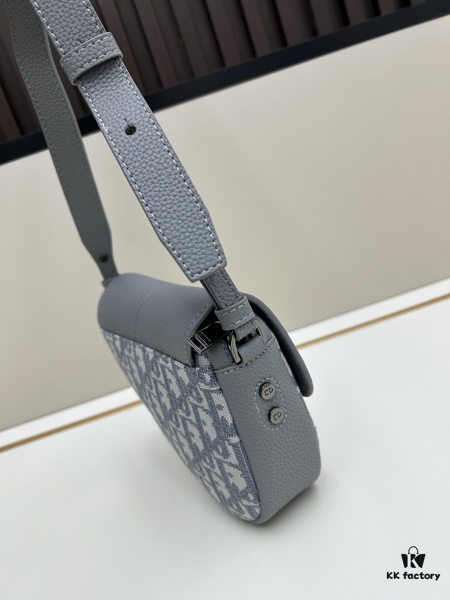 This saddle bag reinterprets the classic design with a modern structure. Crafted from beige and black Oblique print fabric, it features a signature black grained calfskin magnetic flap and a concealed zip closure. The interior includes a large compartment and slip pockets for organizing daily essentials. The mini style comes with an adjustable, detachable leather shoulder strap, allowing for handheld, shoulder, or crossbody wear.