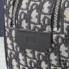 This toiletry bag combines practical functionality with minimalist design, crafted in beige and black Oblique printed fabric with black grained leather trims, featuring the Dior logo on the front.