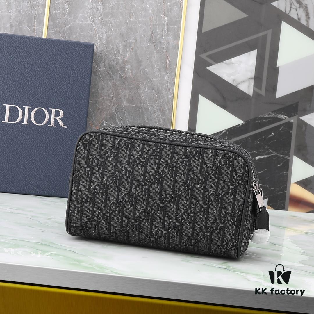 This toiletry bag combines practical functionality with minimalist design. Crafted from black Oblique-print fabric, it features grained calfskin leather trims in matching tones and is adorned with a Dior signature on the front. The front features a zip pocket, a spacious main zipped compartment, and two slip pockets. Equipped with a leather handle, it can be carried by hand or stored inside various handbags.