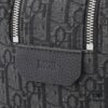 This toiletry bag combines practical functionality with minimalist design. Crafted from black Oblique-print fabric, it features grained calfskin leather trims in matching tones and is adorned with a Dior signature on the front. The front features a zip pocket, a spacious main zipped compartment, and two slip pockets. Equipped with a leather handle, it can be carried by hand or stored inside various handbags.
