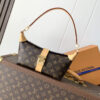 Louis Vuitton This Pochette Mia handbag, part of the Monogram collection, features a Monogram canvas body accented with cowhide leather trim.