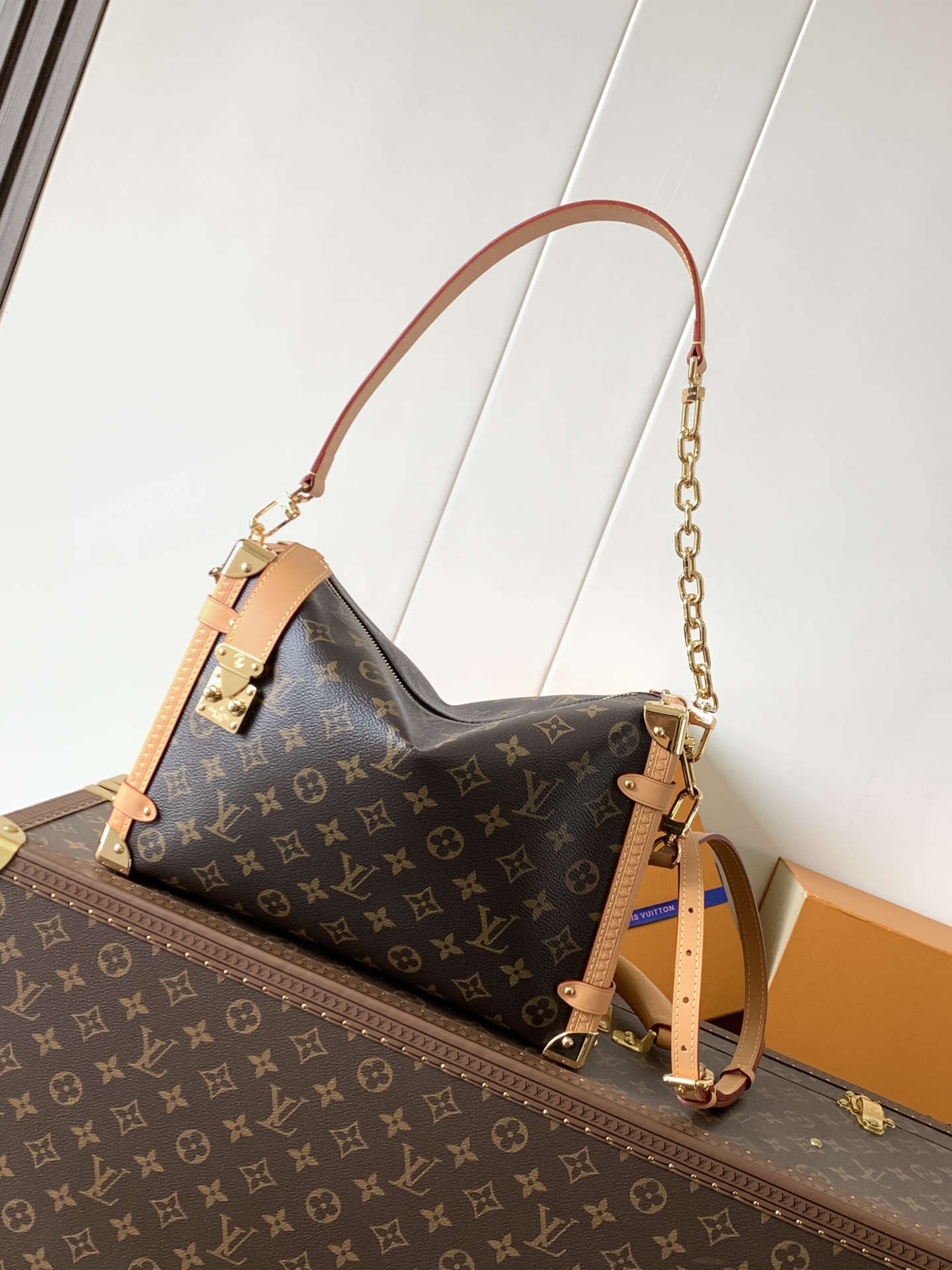 Louis Vuitton This large Side Trunk handbag features Monogram canvas accented with contrasting leather trim.