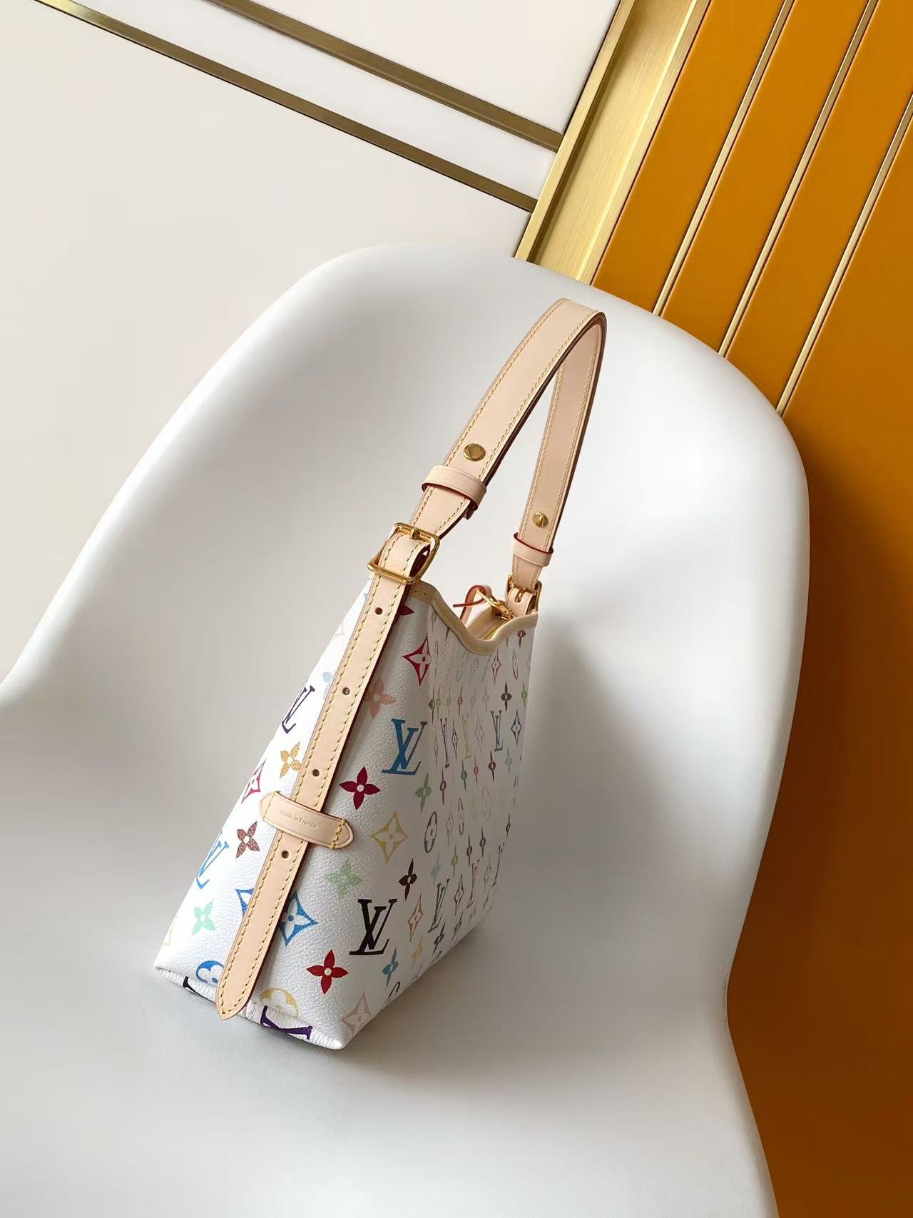 Louis Vuitton This Carryall East-West canvas handbag illuminates this classic element with a vibrant splash of color.