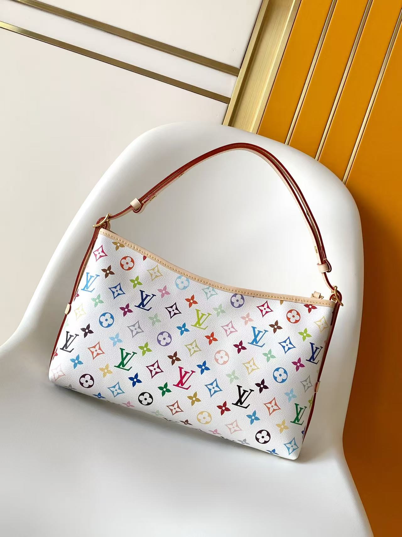 Louis Vuitton This Carryall East-West canvas handbag illuminates this classic element with a vibrant splash of color.