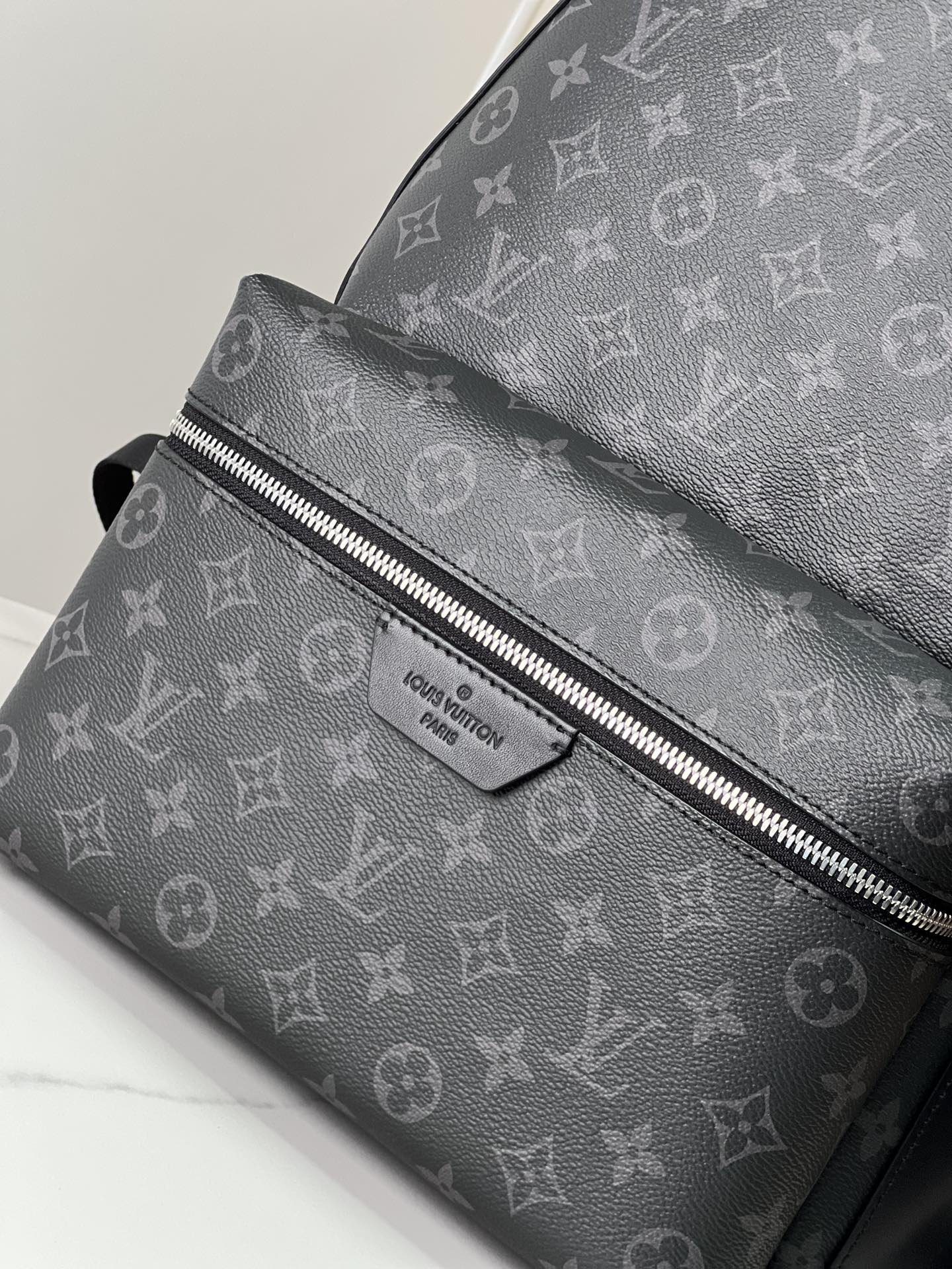 Crafted from Monogram Eclipse canvas, this small Discovery backpack retains its versatile functionality in a more compact silhouette.