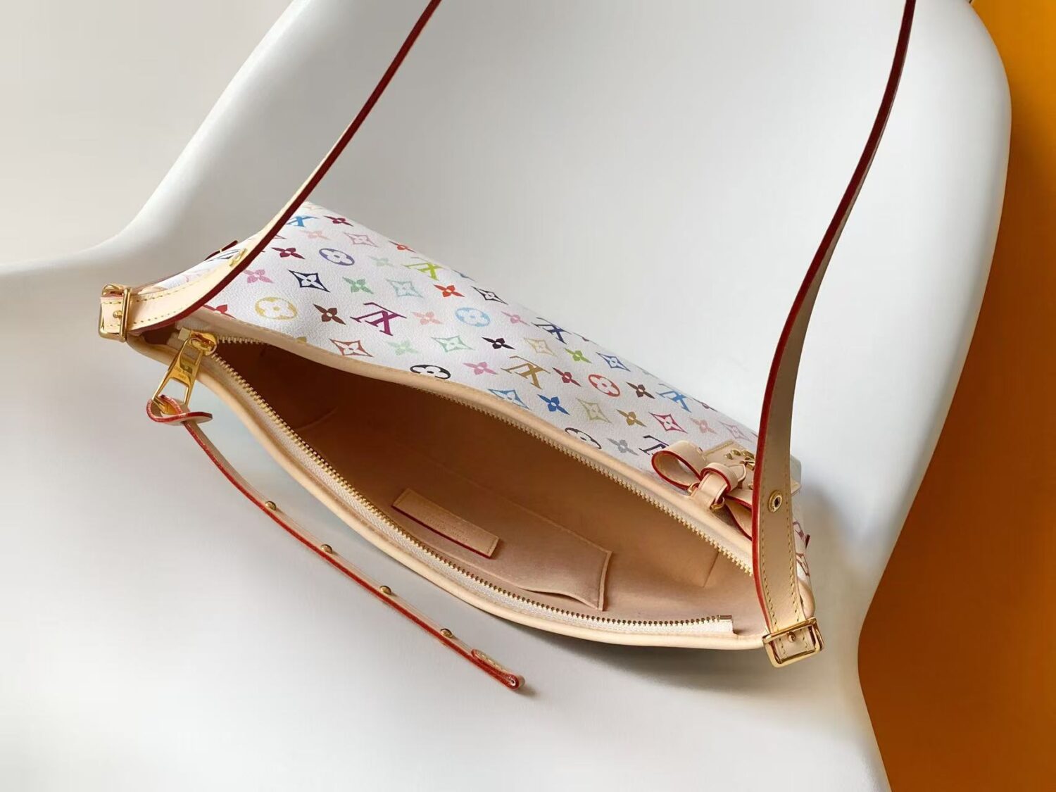 Louis Vuitton This Carryall East-West canvas handbag illuminates this classic element with a vibrant splash of color.