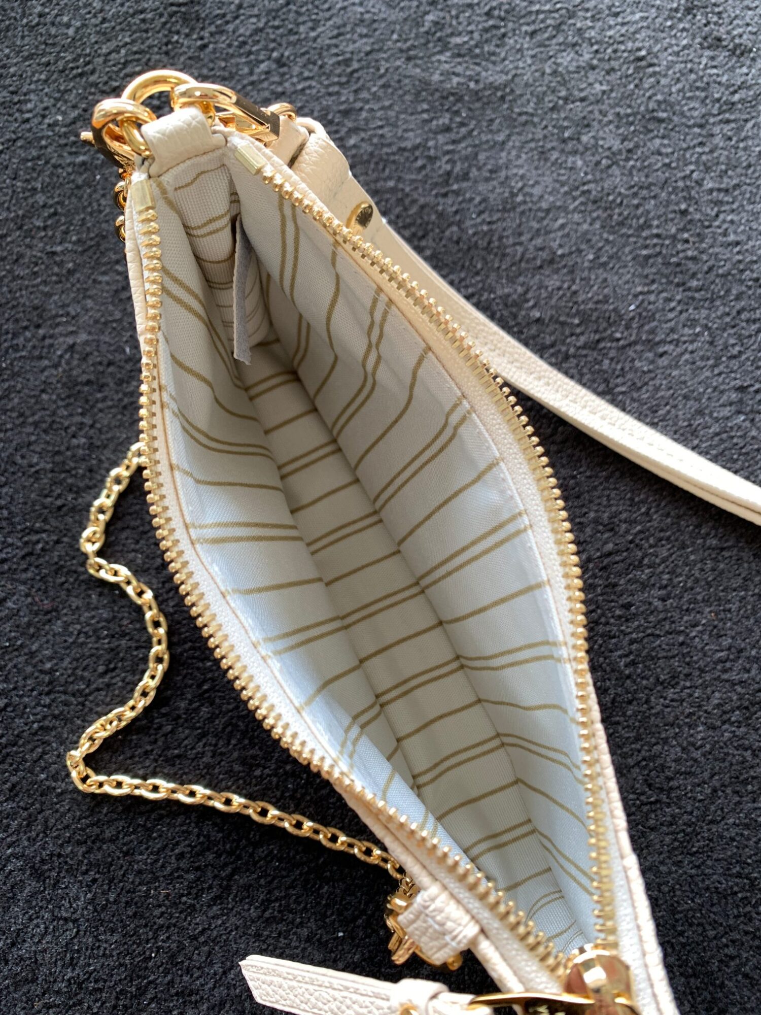 Louis Vuitton The Easy Pouch On Strap handbag from the Spring 2022 Collection is crafted from Monogram Empreinte leather.