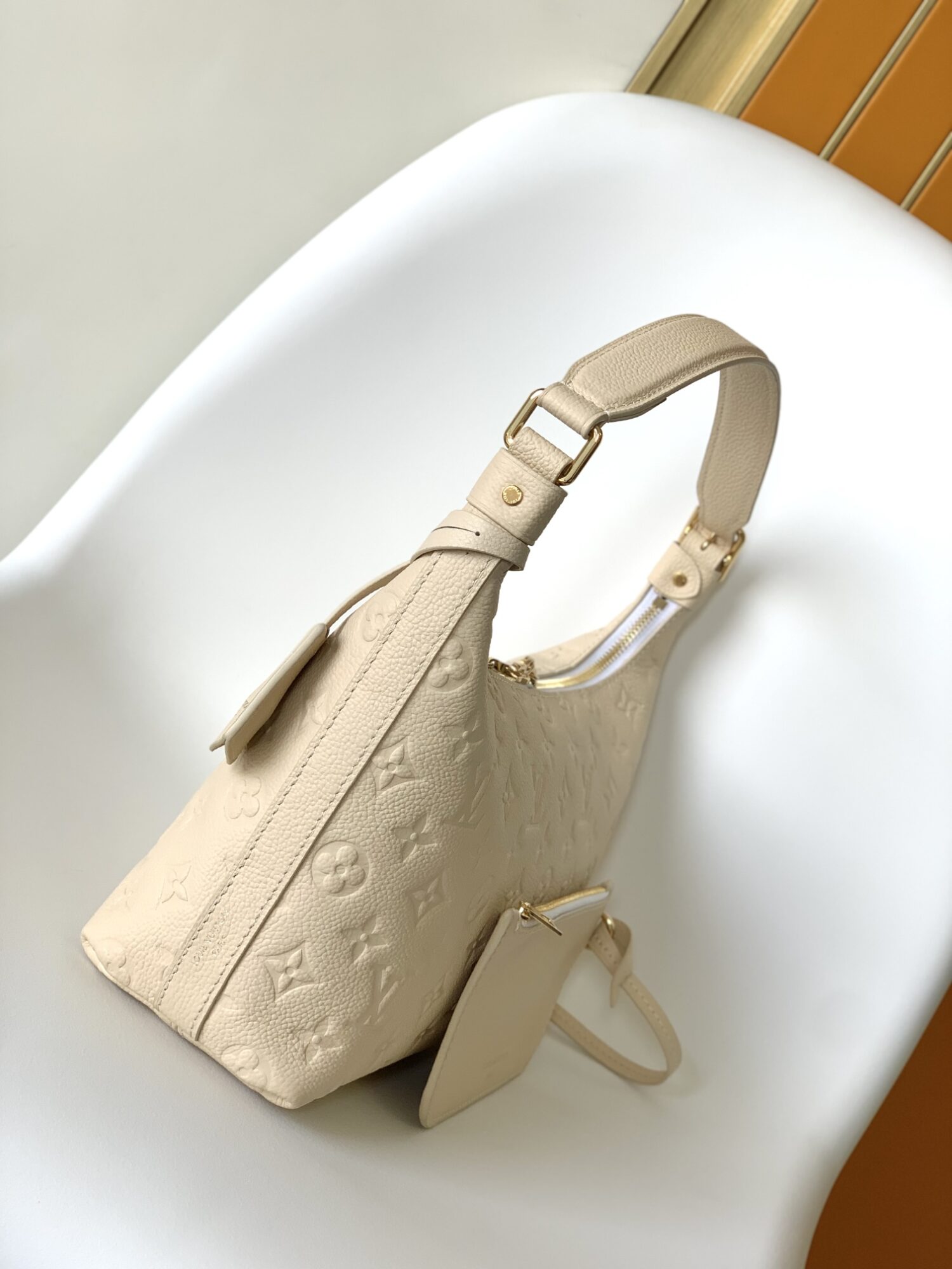 Louis Vuitton The Sac Sport handbag features a curved silhouette crafted from supple Monogram Empreinte embossed leather.