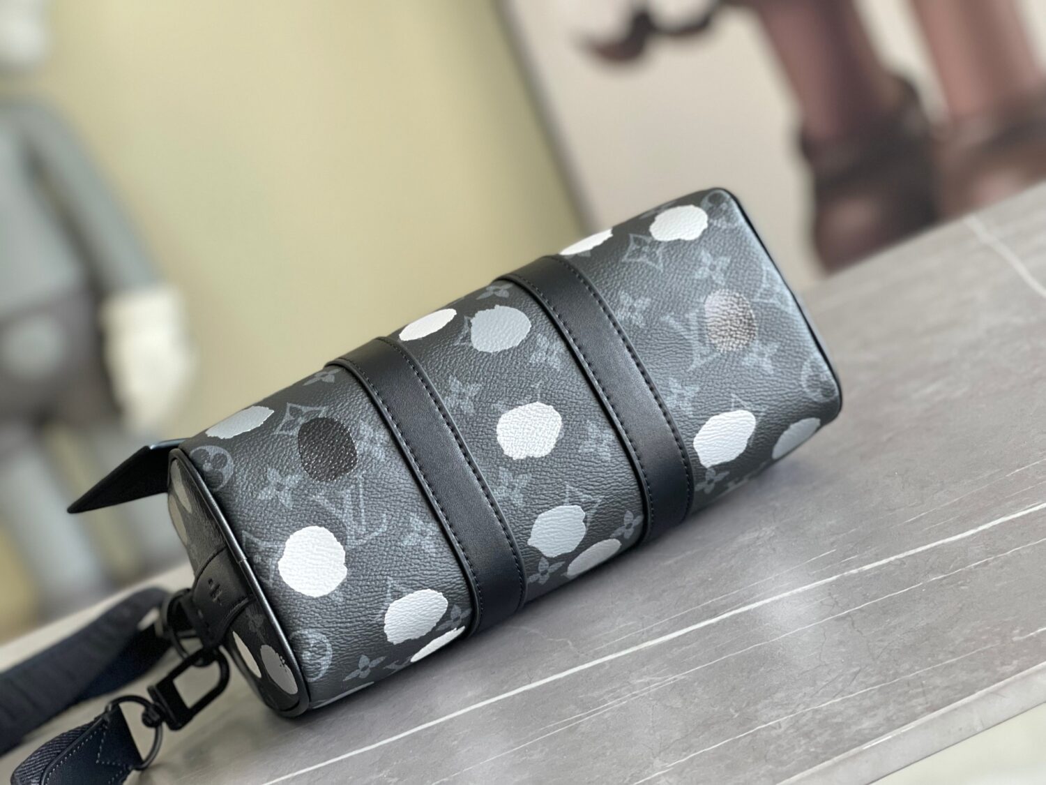 Louis Vuitton M46406 Black Floral Polka Dot Yayoi Kusama Handbag: This handbag encapsulates the classic silhouette of a travel bag and is crafted from embossed leather.